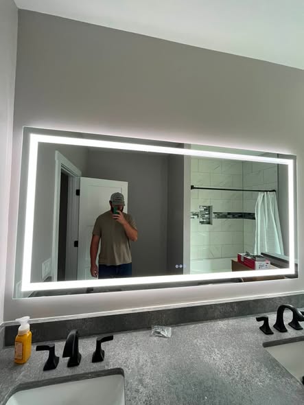 DainCo illuminated mirror and recessed lights in a bathroom